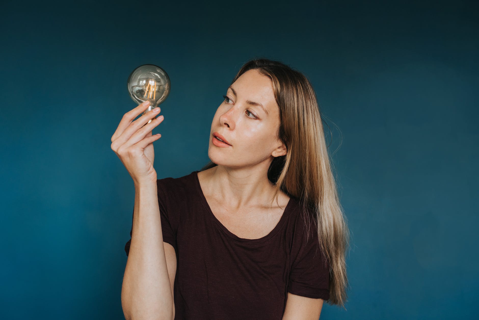 young woman holding light bulb in studio
